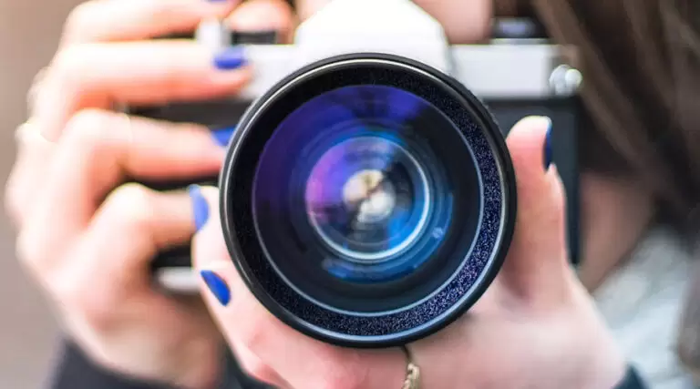 close up of a camera lens in the hands of a women
