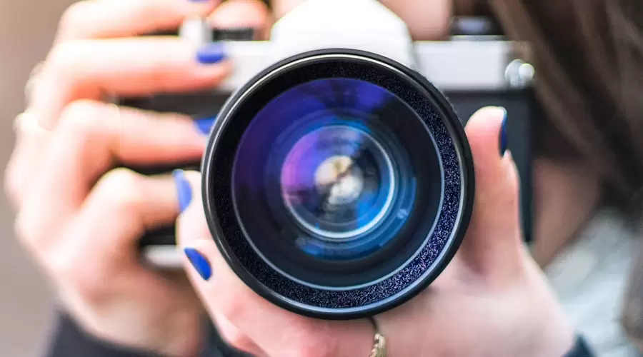 close up of a camera lens in the hands of a women